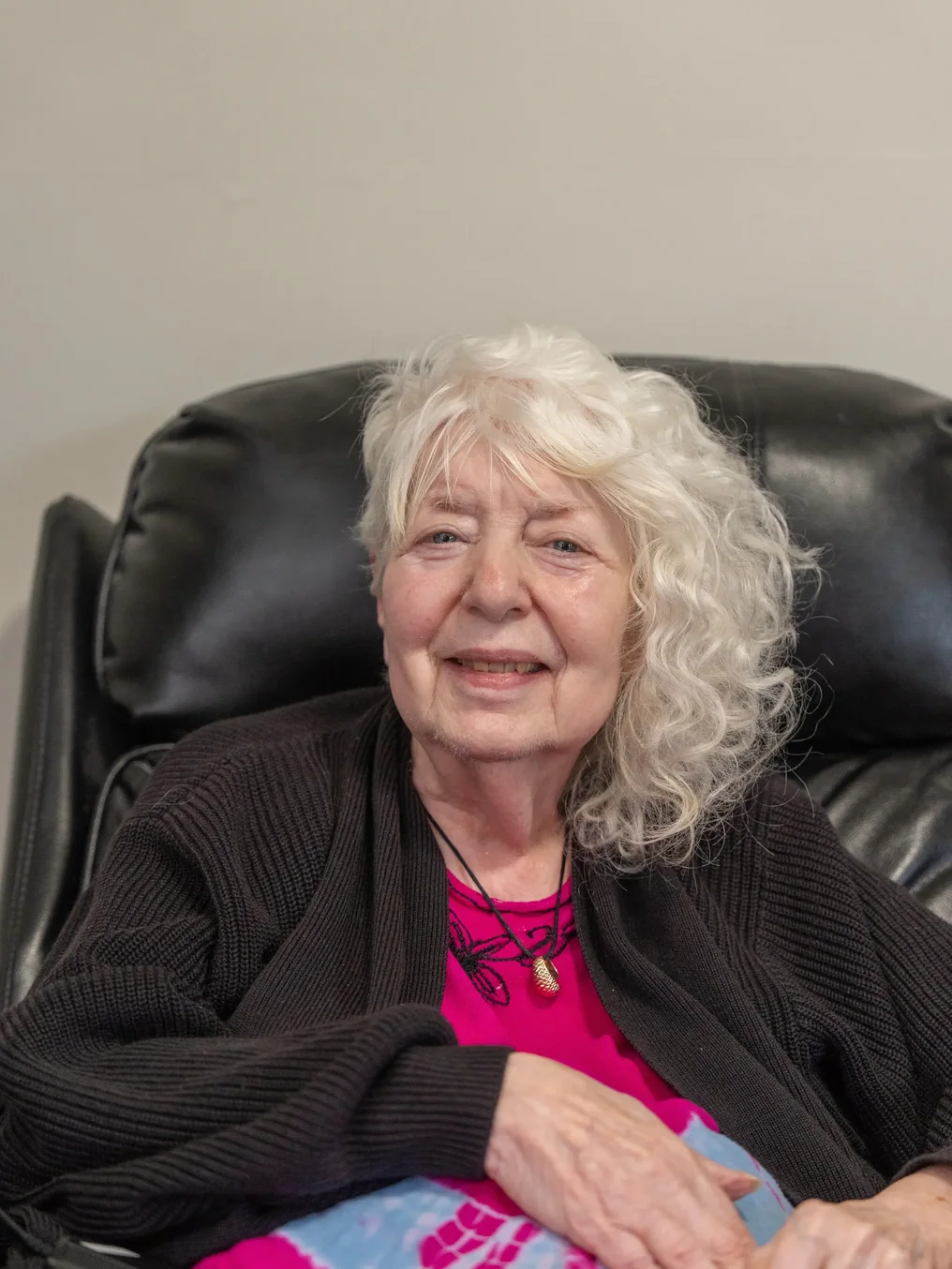 Smiling senior resident relaxing in a leather recliner