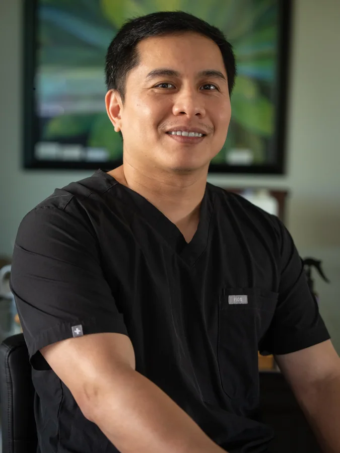 Smiling healthcare professional in black medical scrubs