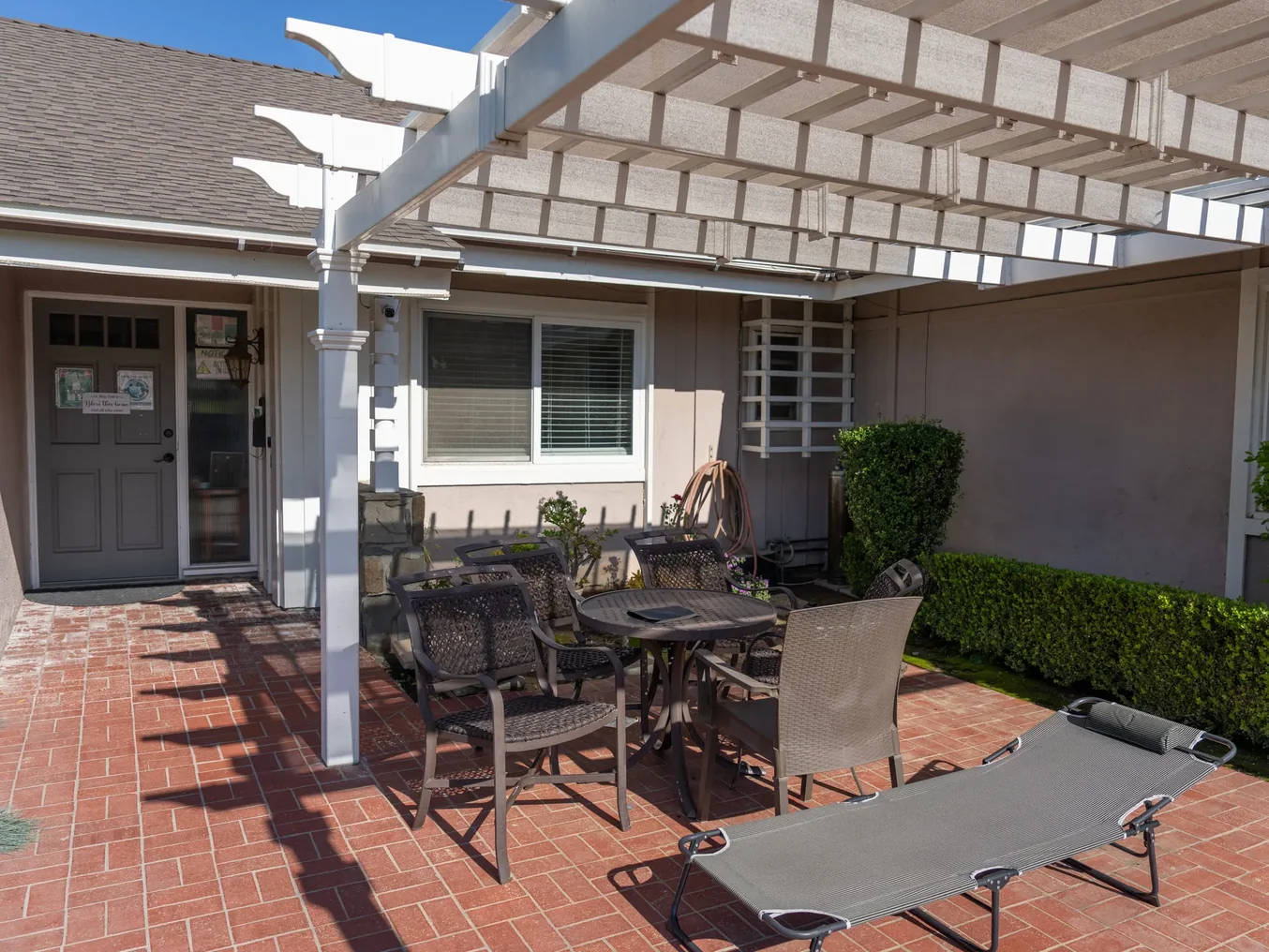 Covered outdoor patio with pergola and brick flooring at the residential care facility
