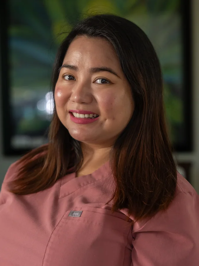 Friendly caregiver in pink scrubs smiling warmly